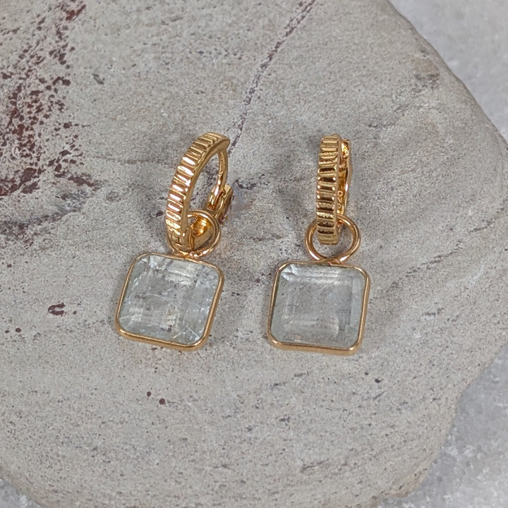 Gold hoop earrings with square blue topaz gemstones