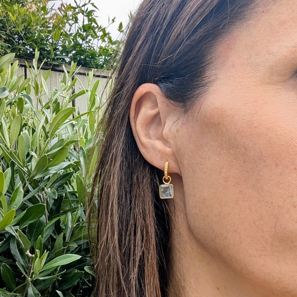 Gold hoop earrings with square blue topaz gemstones