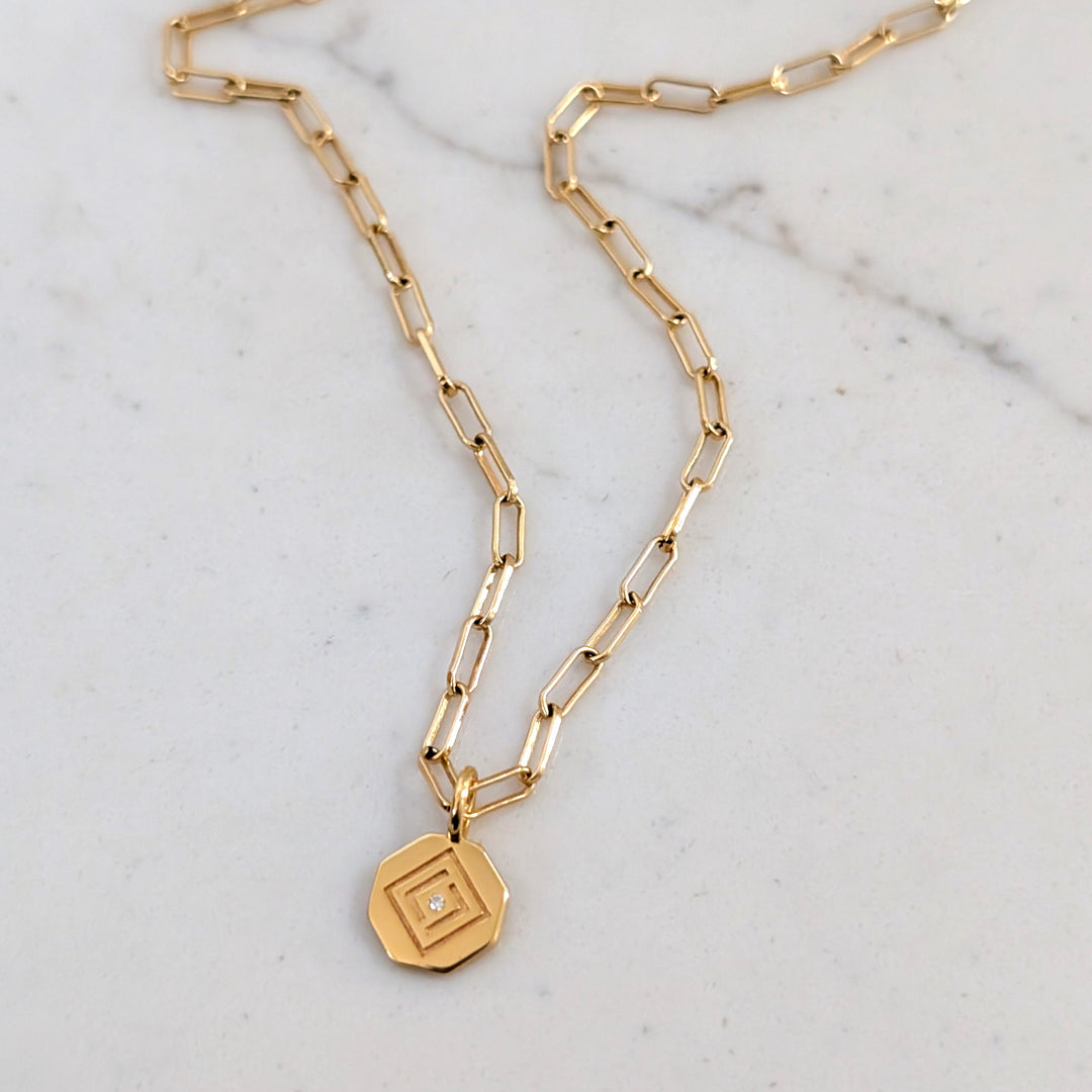 gold paperclip chain with Lapis London logo disc charm