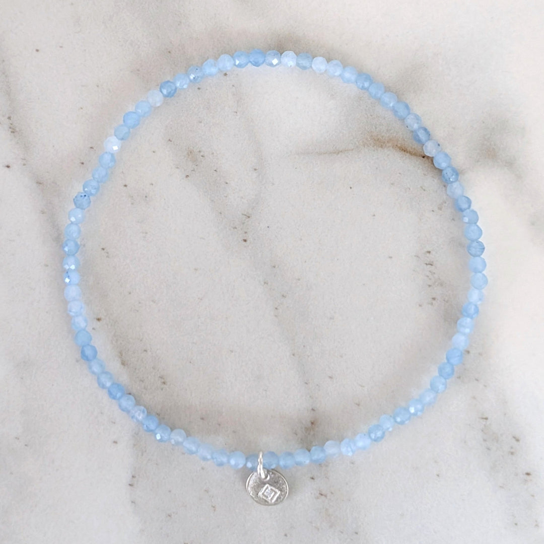 Light blue 2mm beaded aquamarine bracelet with a silver charm 