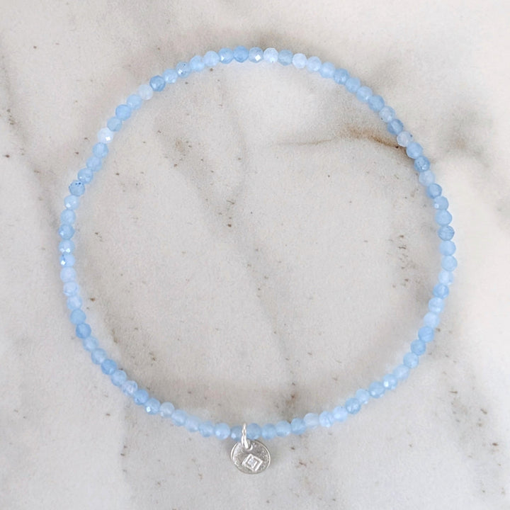 Light blue 2mm beaded aquamarine bracelet with a silver charm 