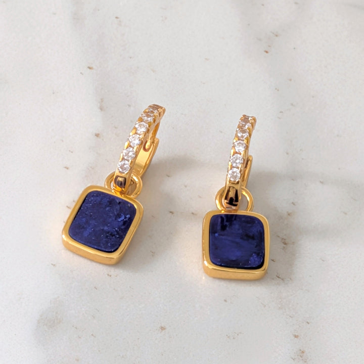 A pair of gold lapis lazuli square charms on eternity hoop earrings 