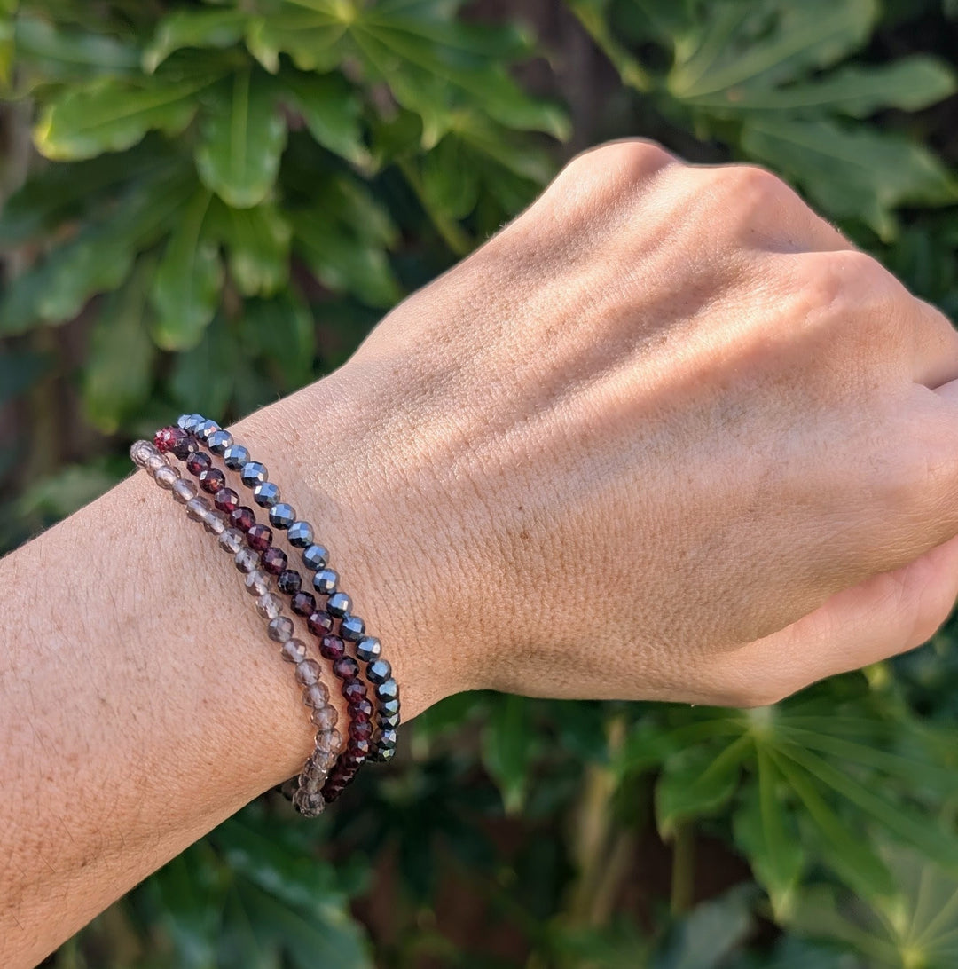 Capricorn gemstone bracelet set comprising hematite, garnet and smoky quartz gemstone bracelets.