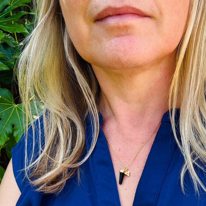 gold necklace with black tourmaline gemstone point pendant and tetrahedron star charm