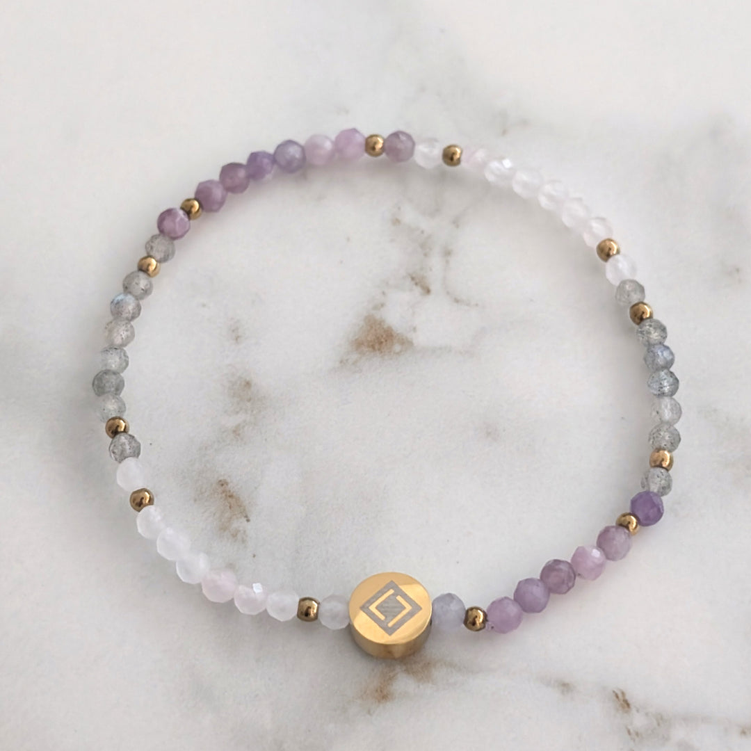 A beaded Libra zodiac stretch bracelet featuring labradorite, lepidolite and rose quartz faceted gemstone beads.