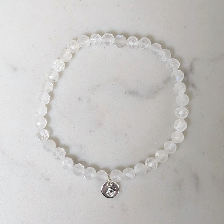 Beaded children's moonstone June birthstone bracelet with a silver disc charm