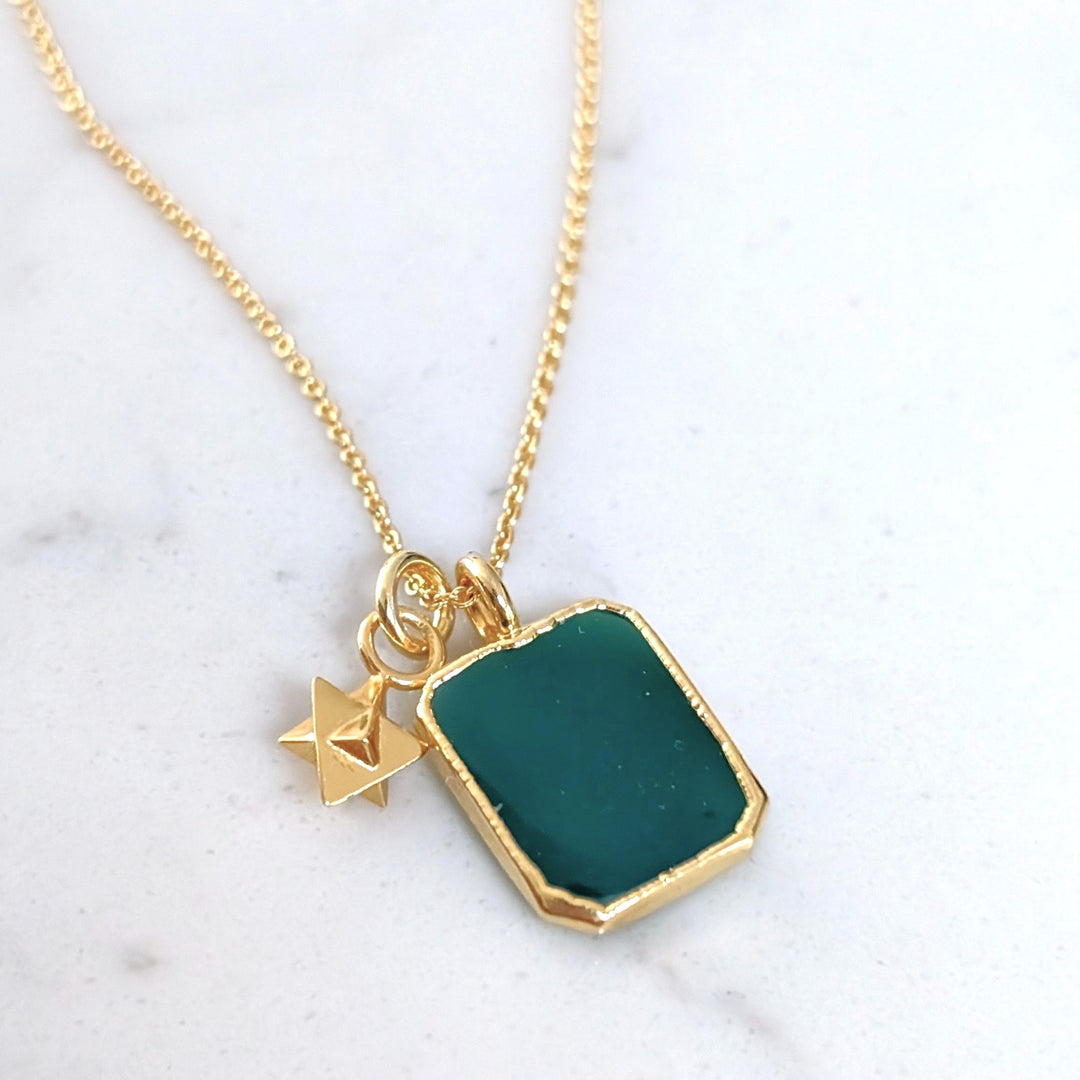 Gold necklace with a green green onyx rectangular pendant and charm