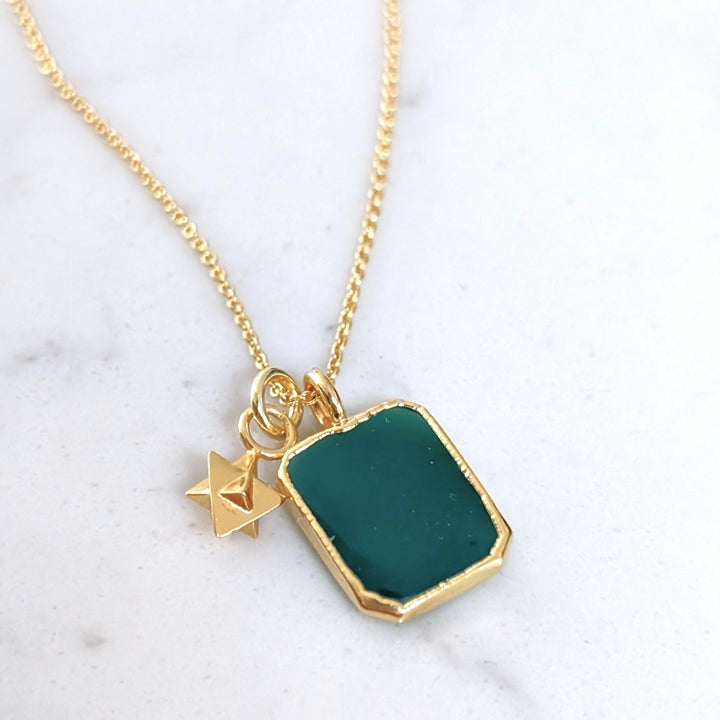 Gold necklace with a green green onyx rectangular pendant and charm