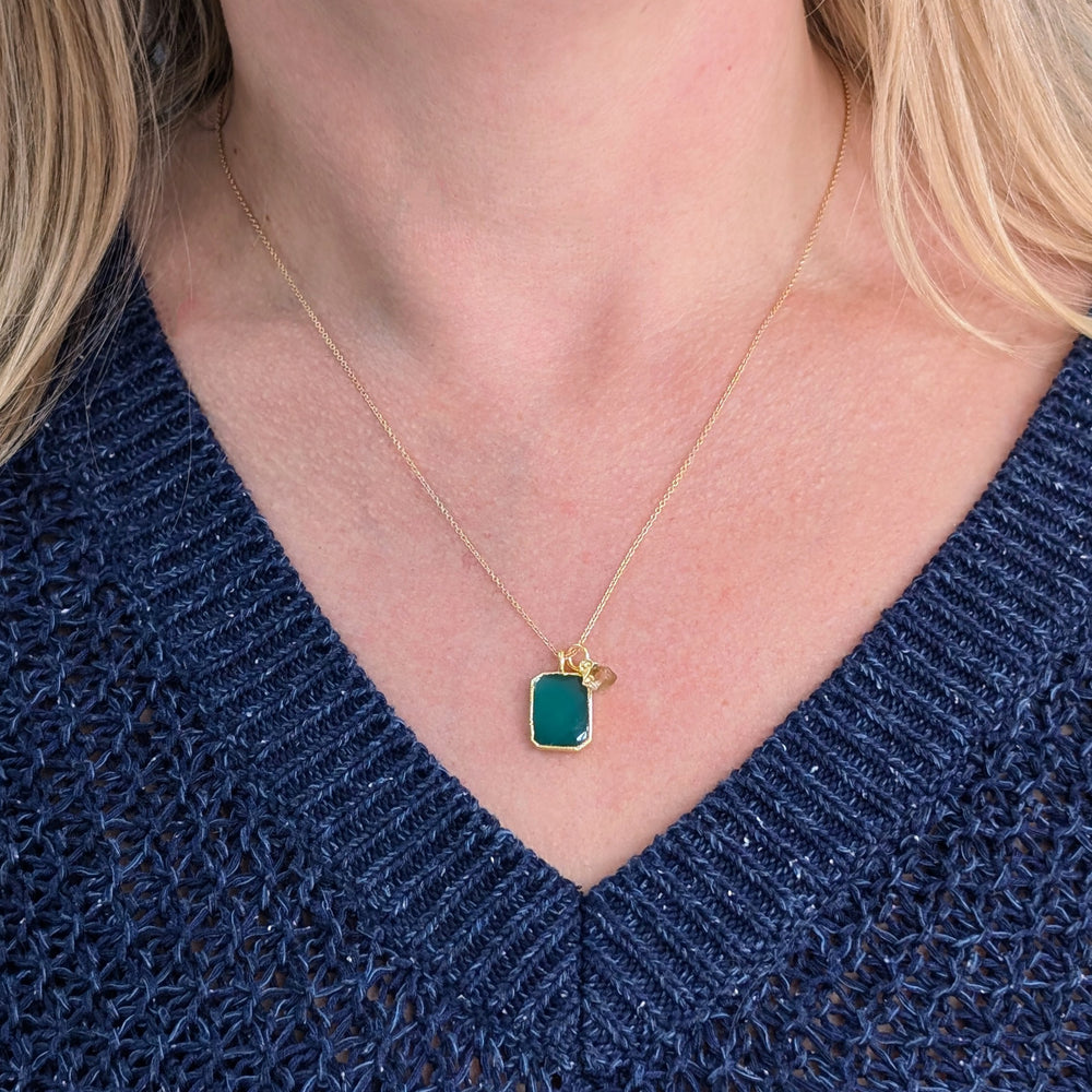 Gold necklace with a green green onyx rectangular pendant and charm