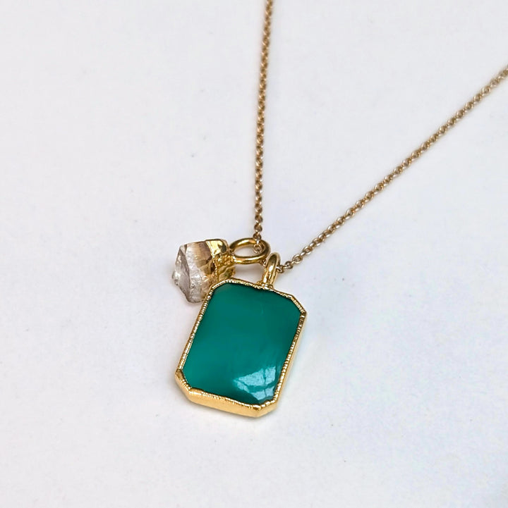 Gold necklace with a green green onyx rectangular pendant and charm