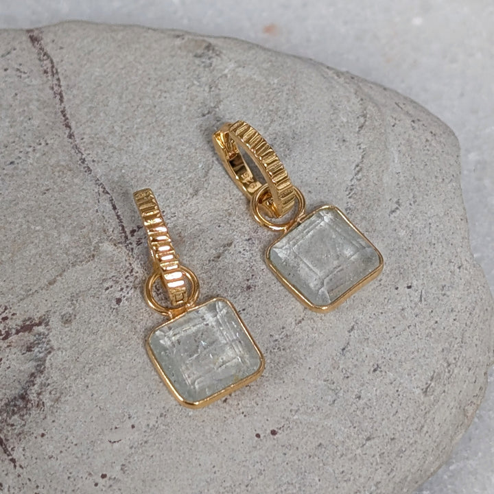 Gold hoop earrings with square blue topaz gemstones 