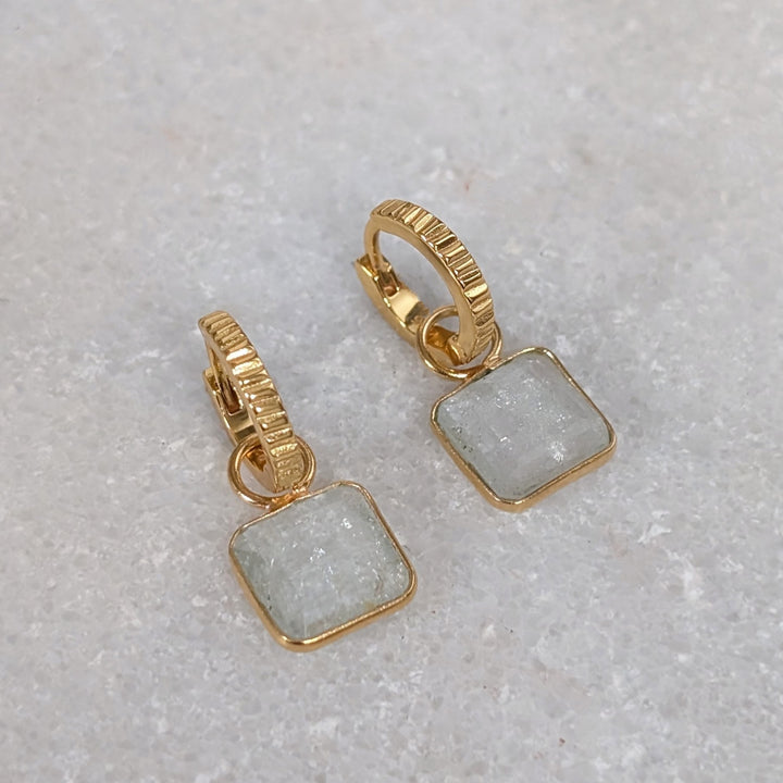 Gold hoop earrings with square blue topaz gemstones 