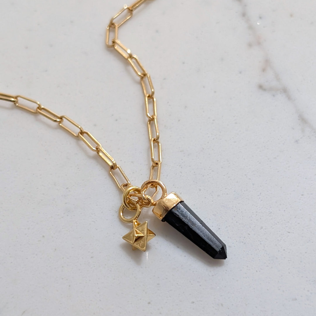 gold paperclip necklace with black tourmaline gemstone point pendant and tetrahedron star charm