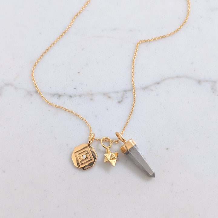 gold necklace with pyrite, tetrahedron star and disc pendant charms