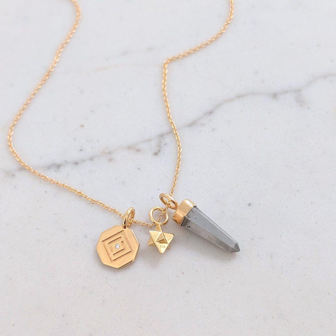 gold necklace with pyrite, tetrahedron star and disc pendant charms