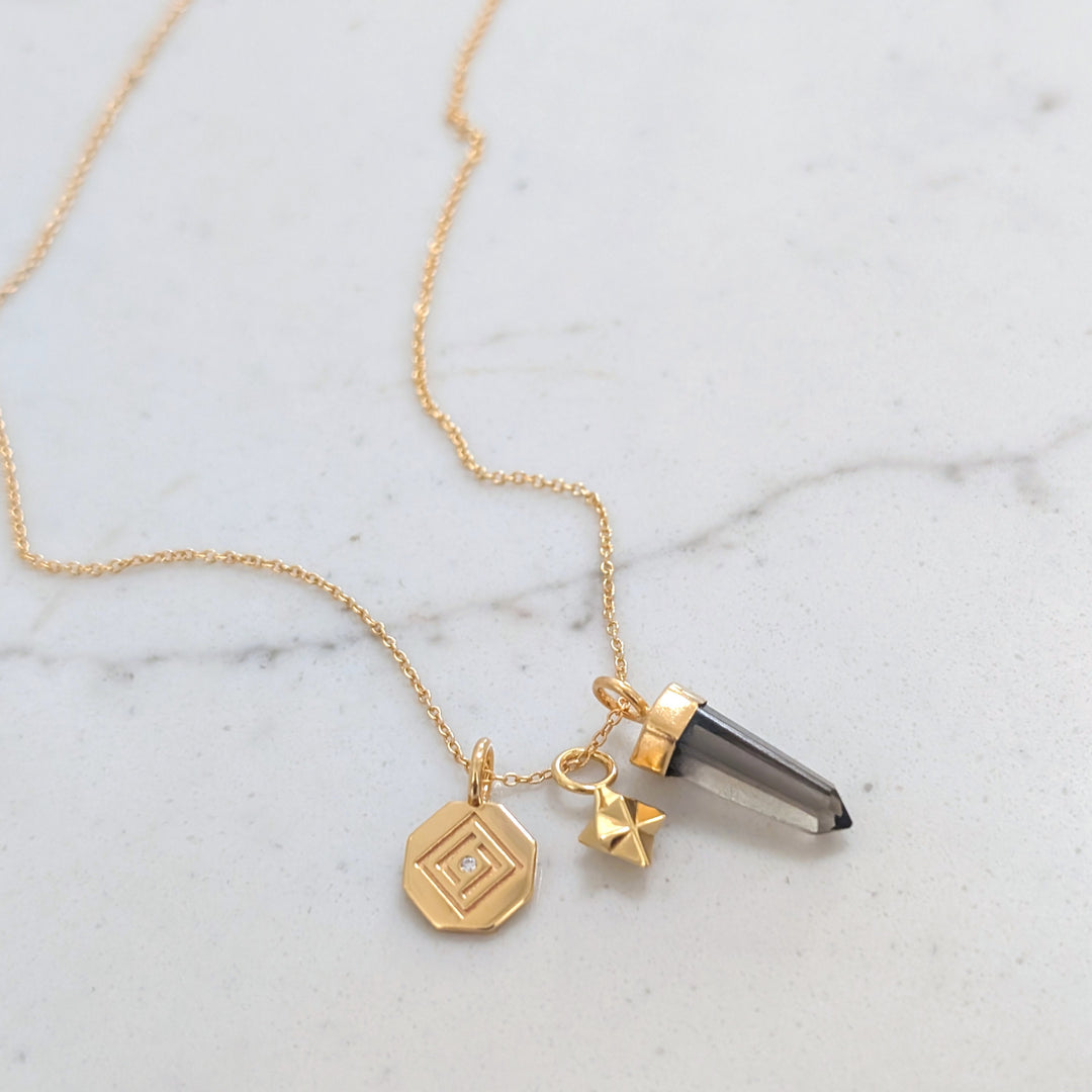 gold necklace with smokey quartz, tetrahedron star and disc pendant charms