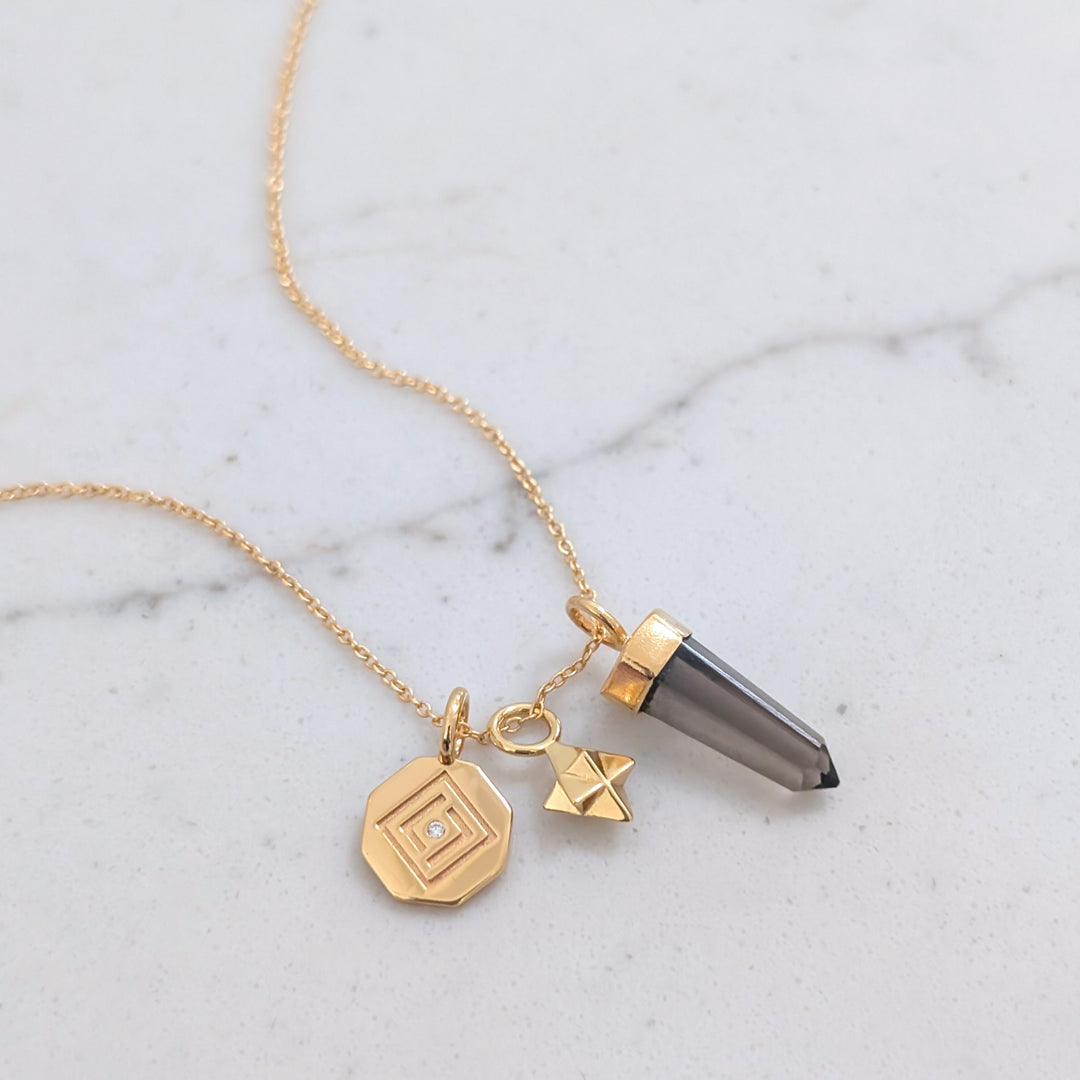 gold necklace with smokey quartz, tetrahedron star and disc pendant charms