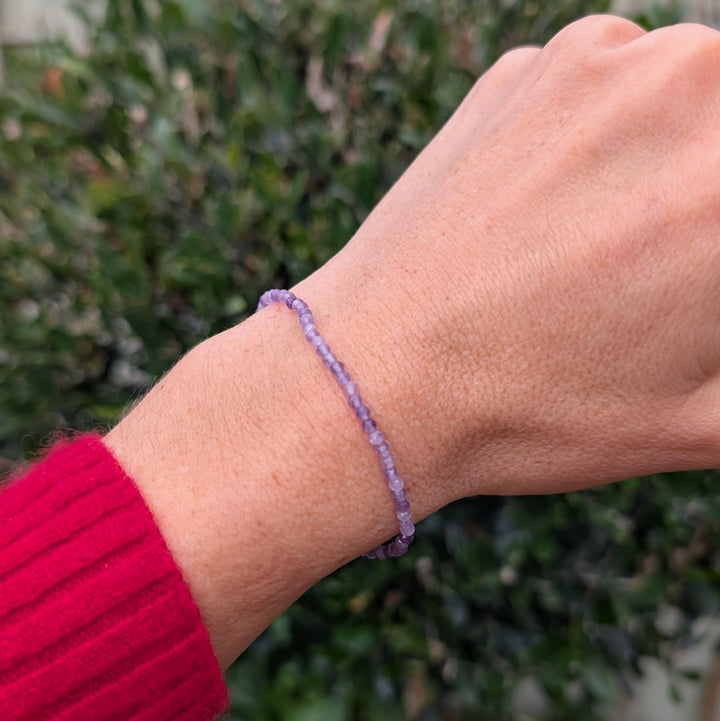 Purple 2mm beaded amethyst bracelet with a silver charm 