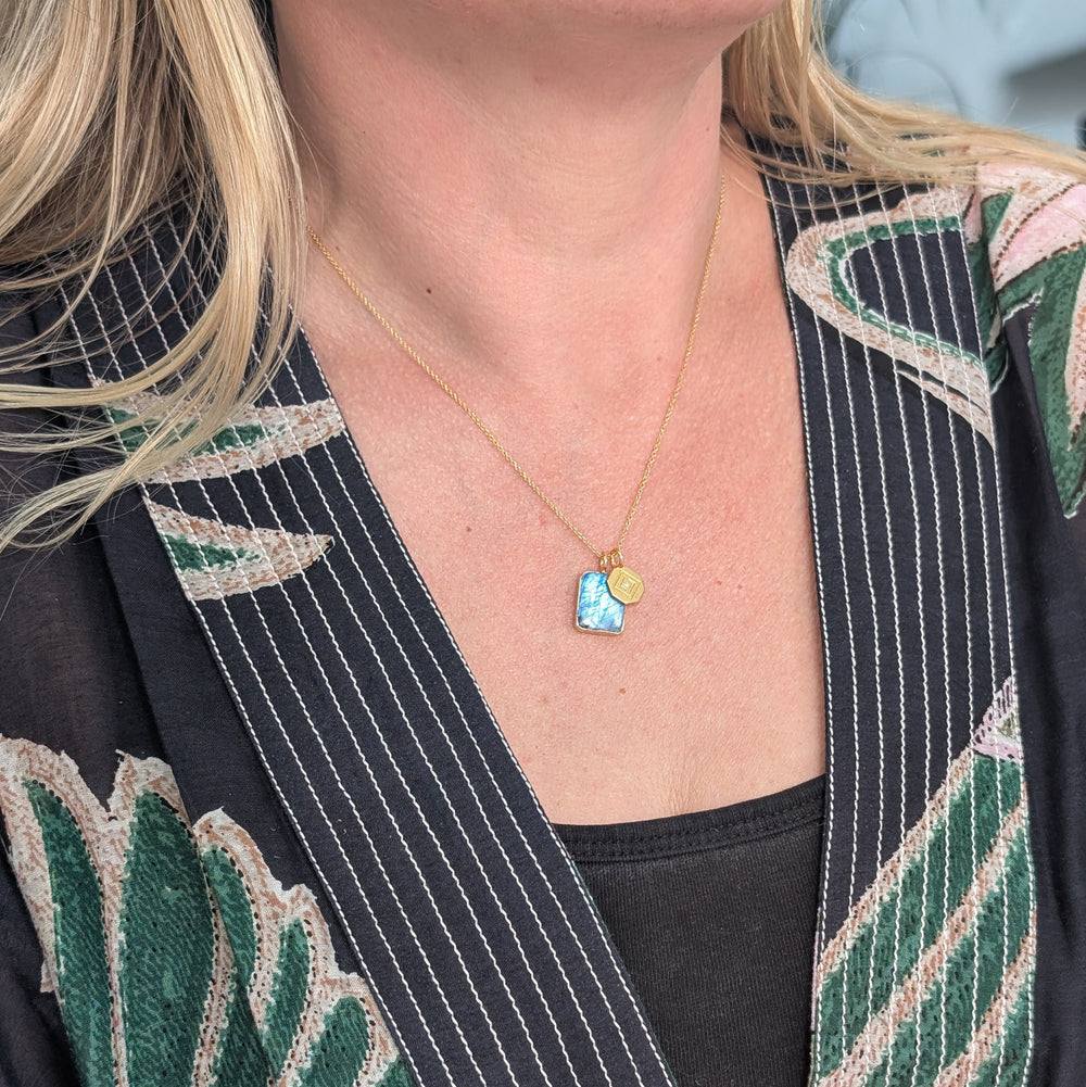 Gold necklace with a blue rectangular labradorite pendant and gold disc