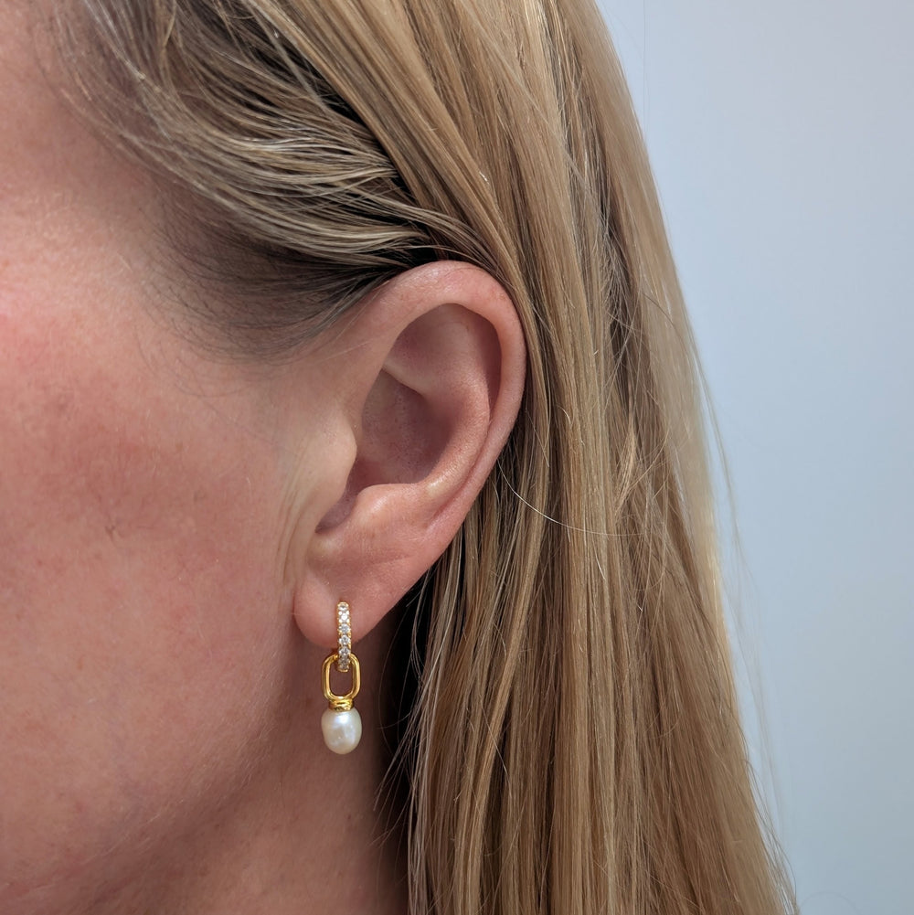 A pair of gold zircon eternity huggie hoop earrings a dangling baroque pearls
