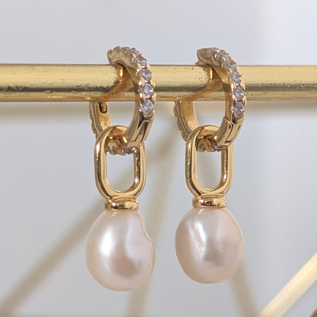 A pair of gold zircon eternity huggie hoop earrings a dangling baroque pearls.