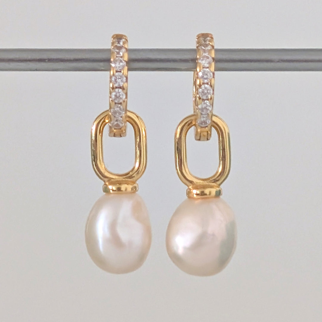 a pair of gold pearl earring charms on eternity huggie hoops