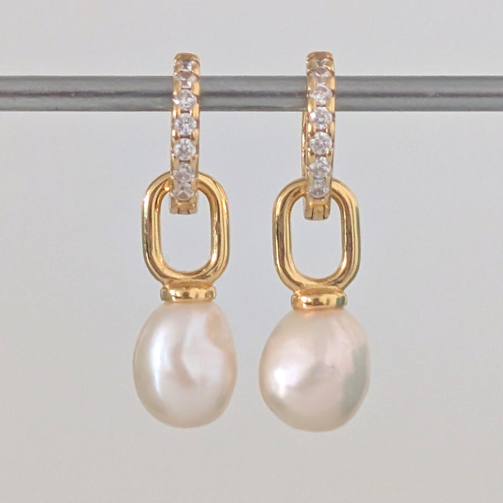 a pair of gold pearl earring charms on eternity huggie hoops