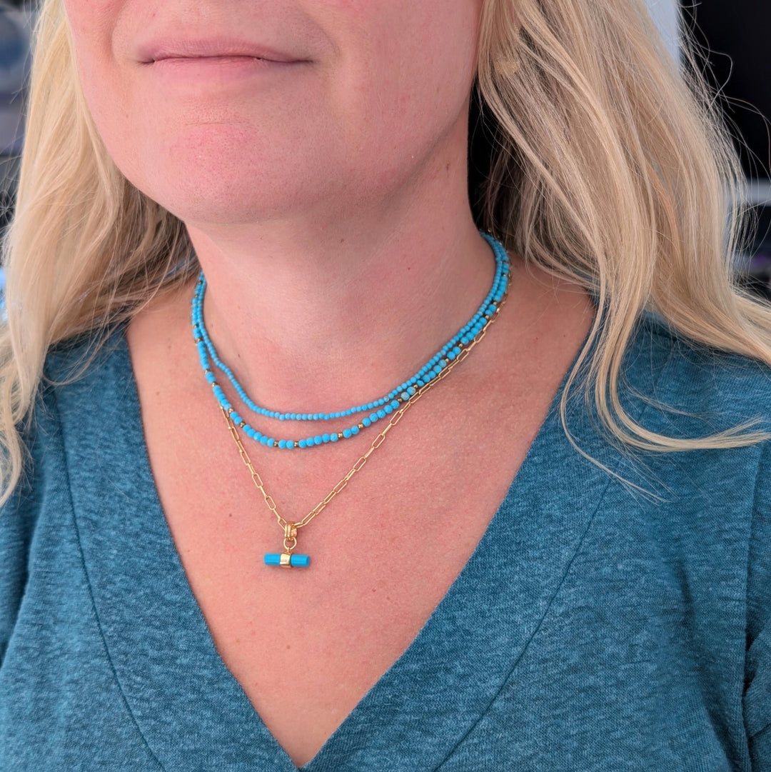 turquoise gemstone and gold bead necklace layered with a turquoise t-bar pendant necklace and skinny turquoise gemstone necklace