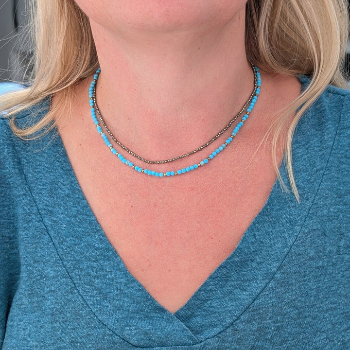 turquoise gemstone and gold bead bead necklace layered with a pyrite skinny necklace
