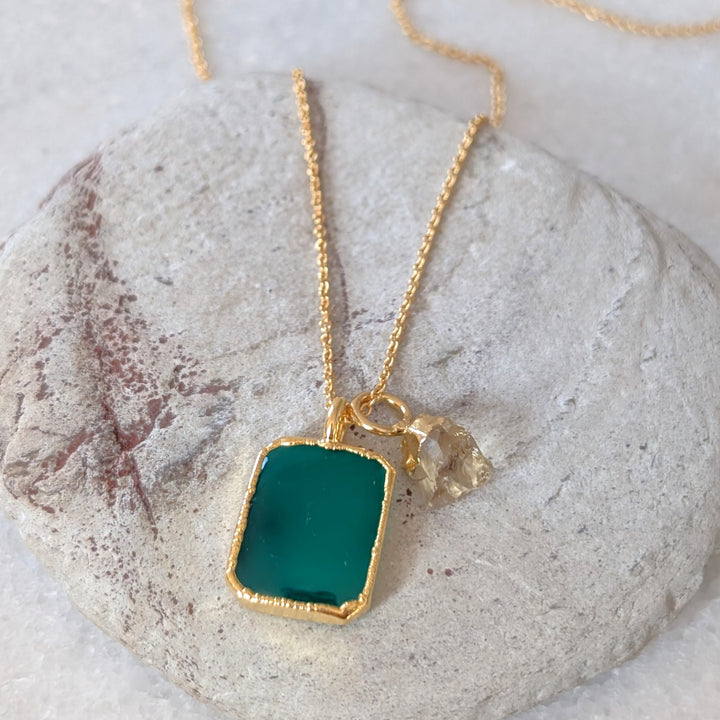 Gold necklace with a green green onyx rectangular pendant and charm