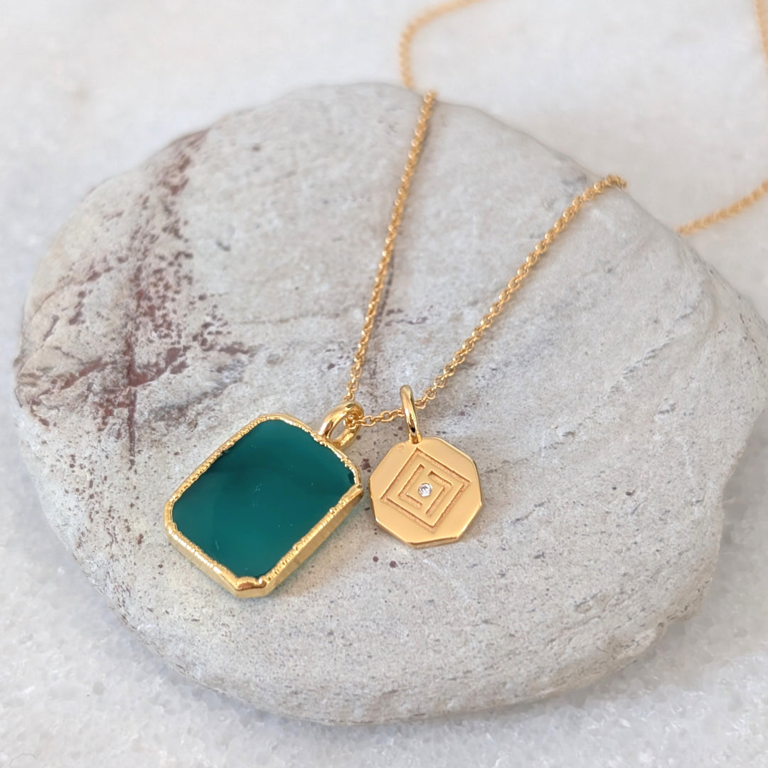 Gold necklace with a green green onyx rectangular pendant and charm