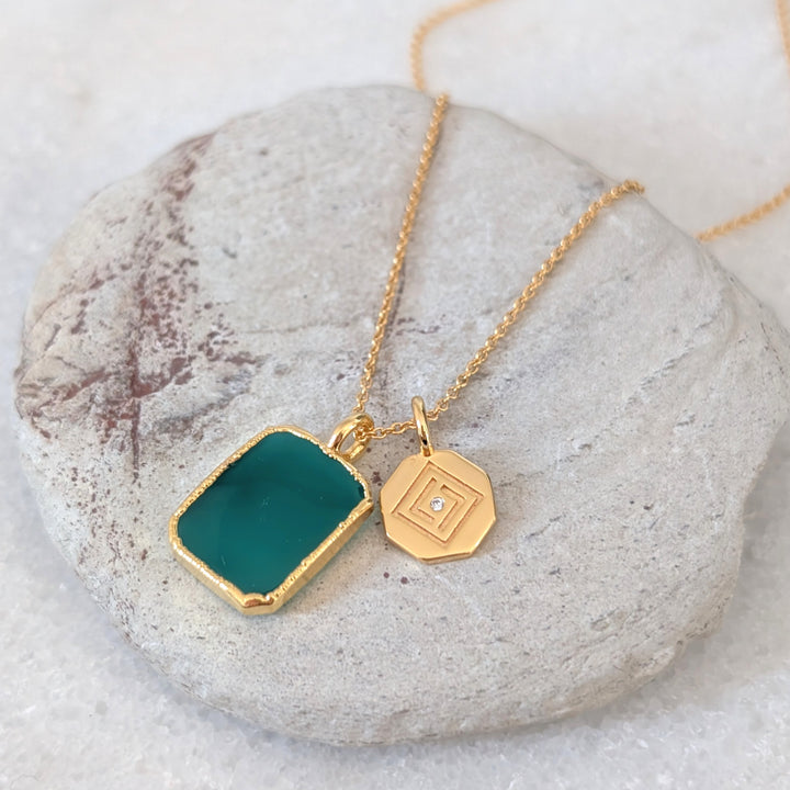 Gold necklace with a green green onyx rectangular pendant and charm