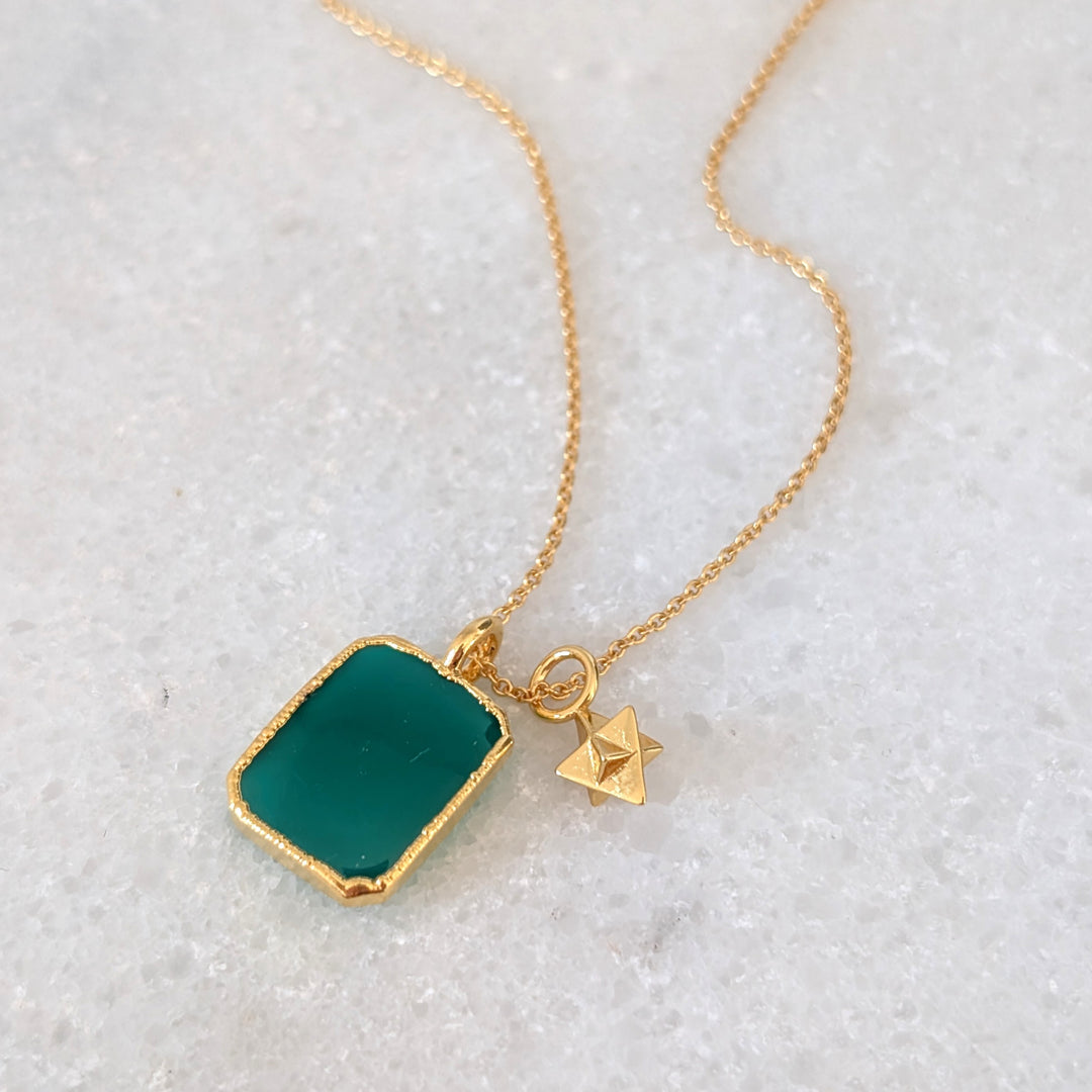 Gold necklace with a green green onyx rectangular pendant and charm