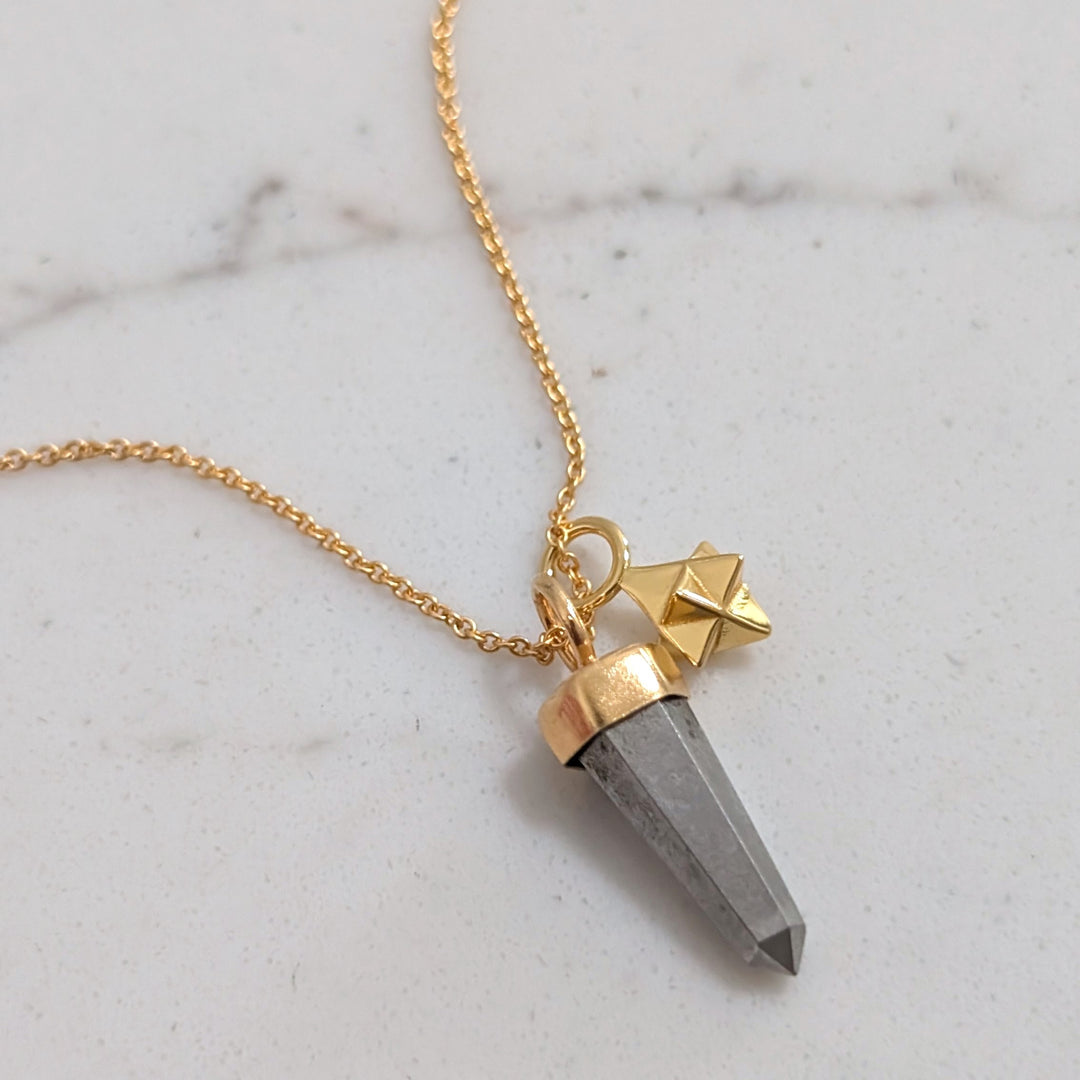 gold necklace with pyrite gemstone point pendant and tetrahedron star charm
