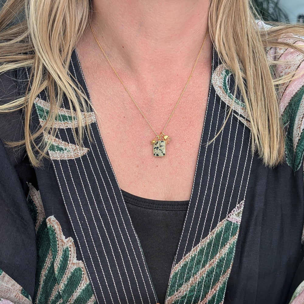 Gold necklace with a dalmatian jasper pendant and citrine charm