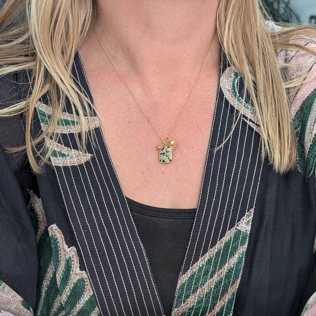 Gold necklace with a dalmatian jasper pendant and citrine charm