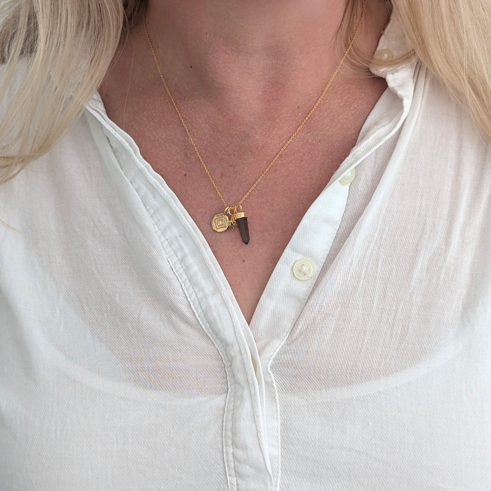 gold necklace with smokey quartz, tetrahedron star and disc pendant charms