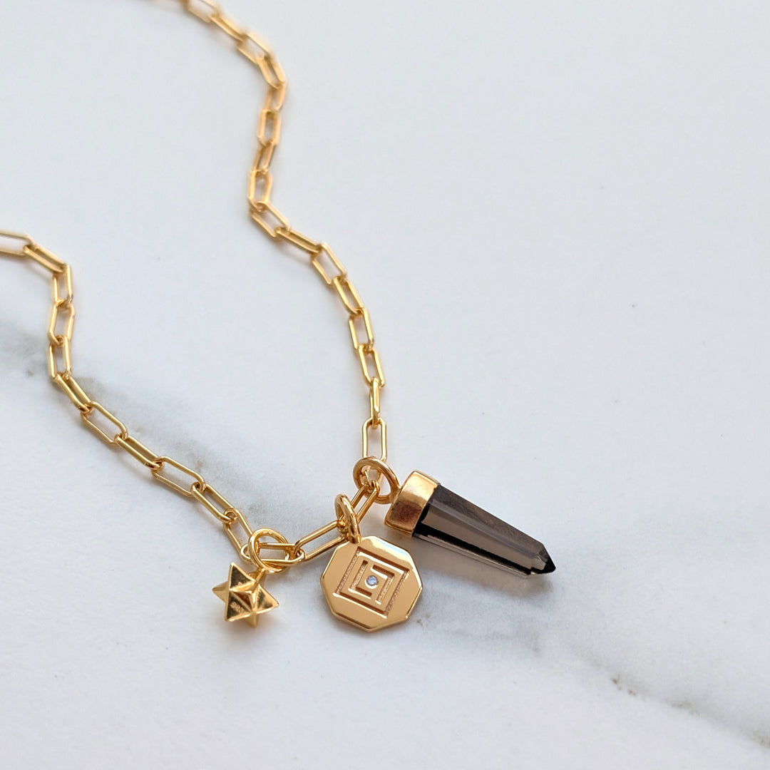 gold necklace with smokey quartz, tetrahedron star and disc pendant charms
