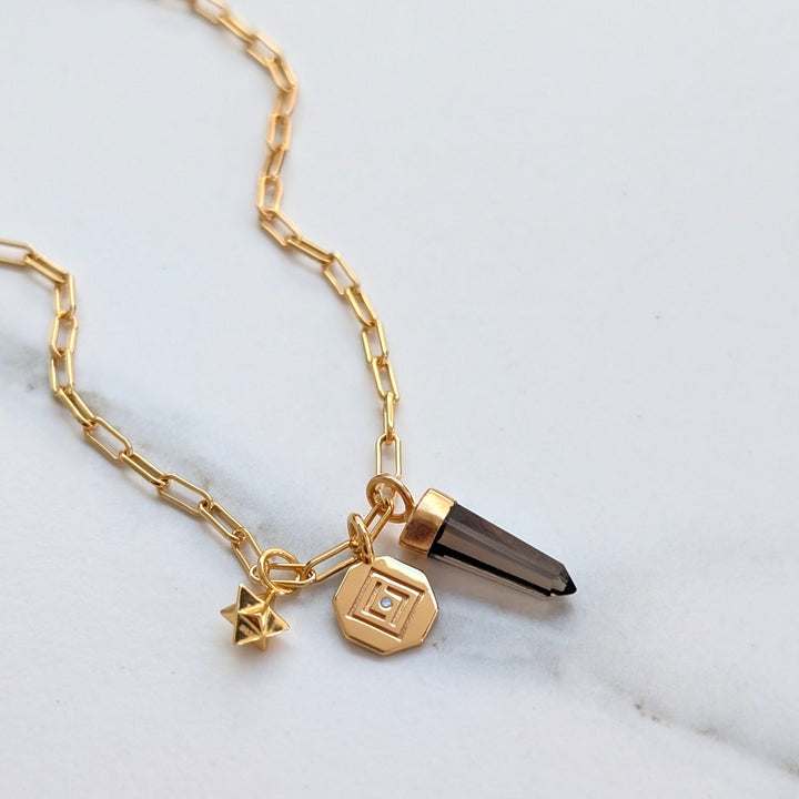 gold necklace with smokey quartz, tetrahedron star and disc pendant charms