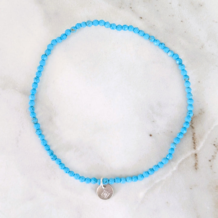 Blue Turquoise 2mm beaded bracelet with a silver charm