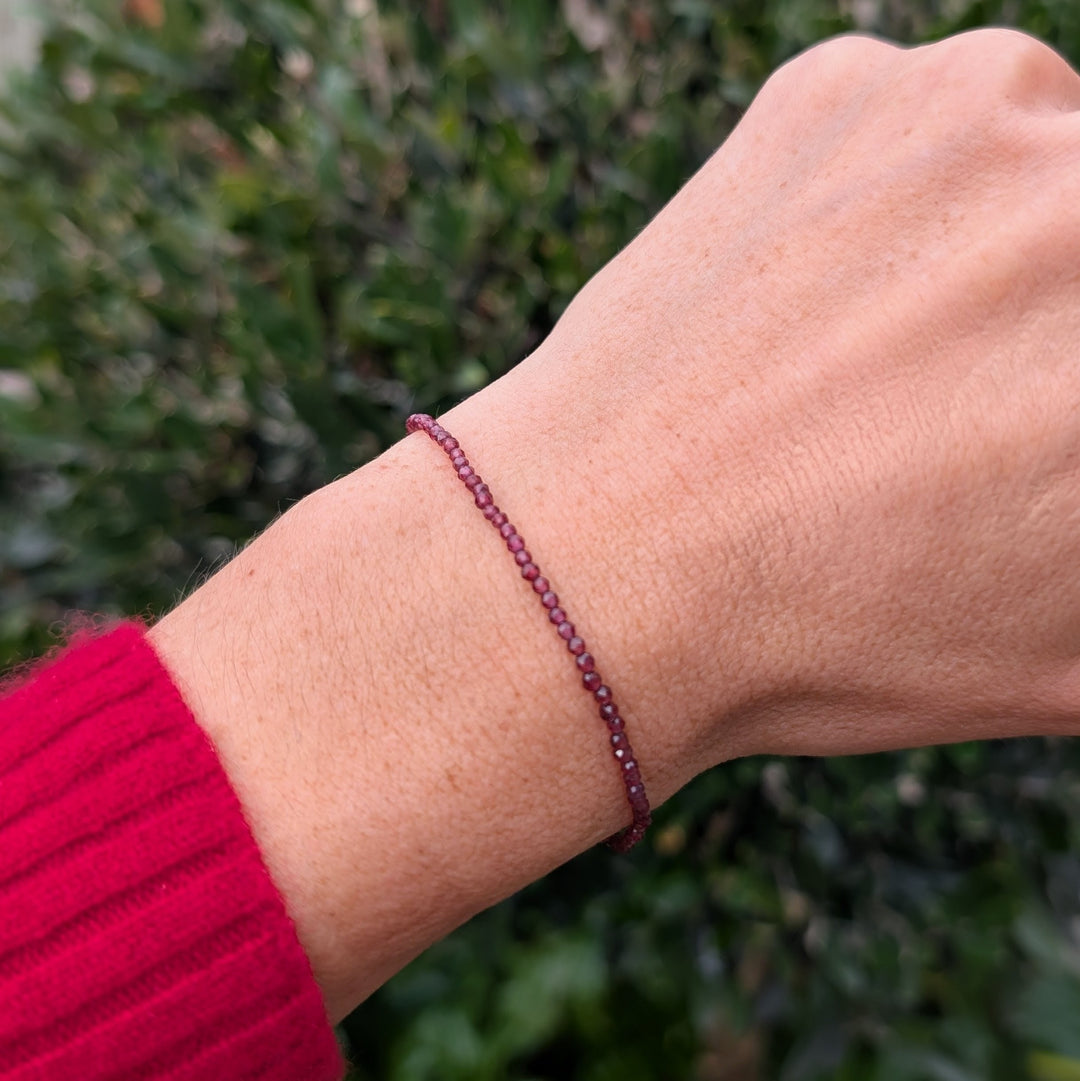 Garnet 2mm beaded bracelet with a silver charm 