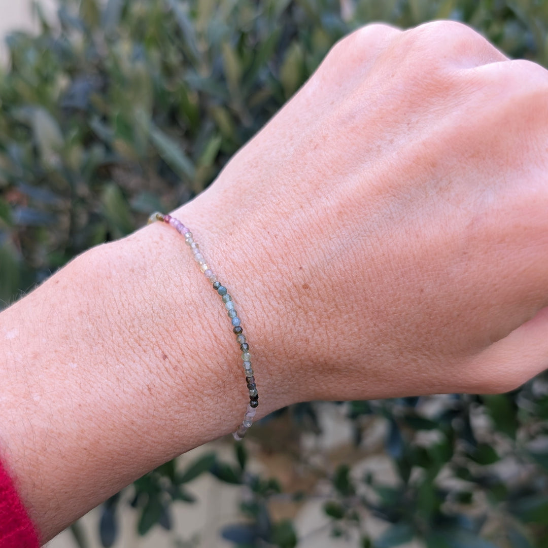 Close-up of a wrist wearing a dainty 2mm beaded watermelon tourmine bracelet