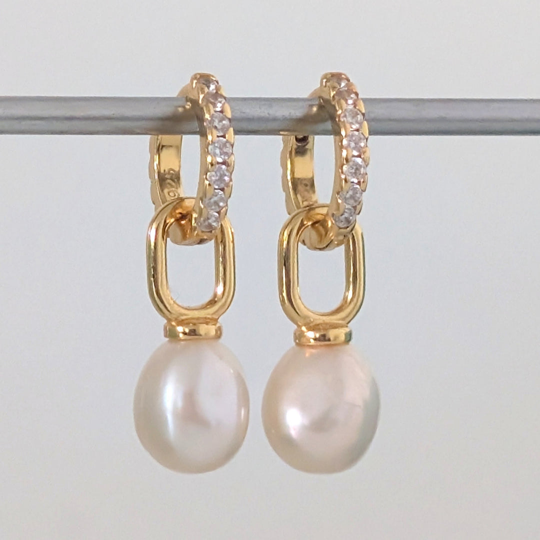 a pair of gold pearl earring charms on eternity huggie hoops