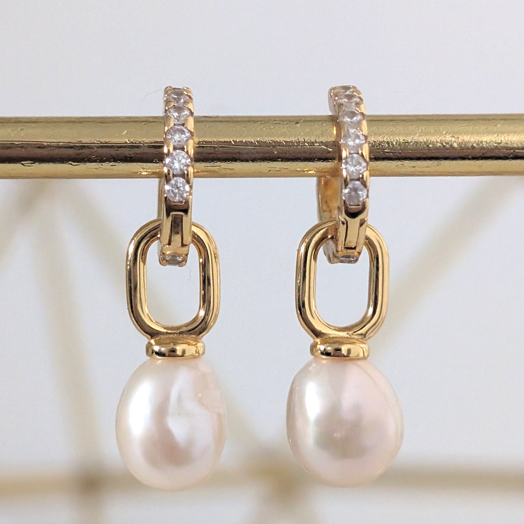 A pair of gold zircon eternity huggie hoop earrings a dangling baroque pearls.