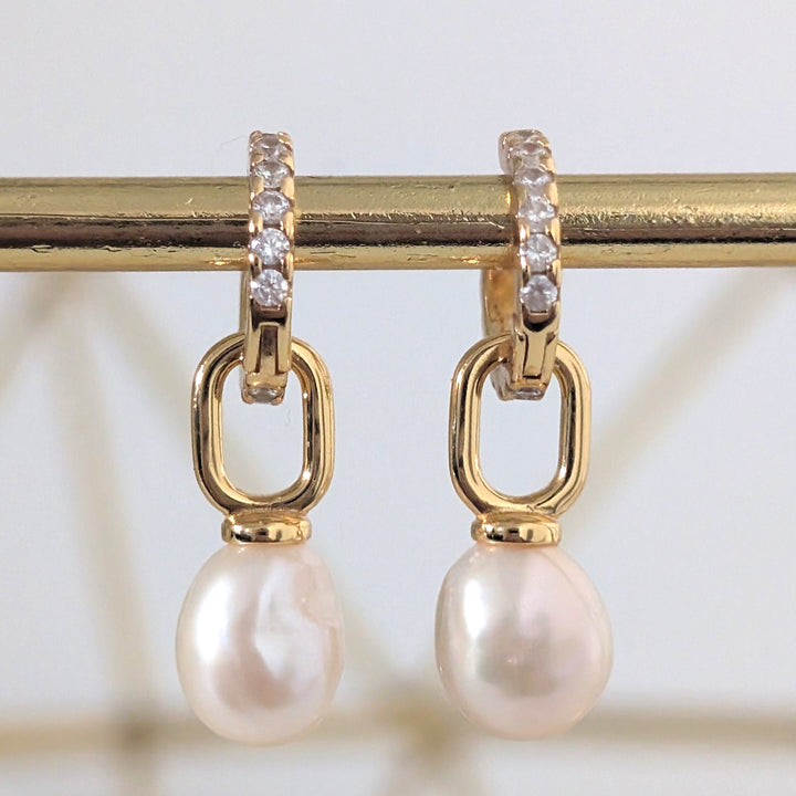 A pair of gold zircon eternity huggie hoop earrings a dangling baroque pearls.