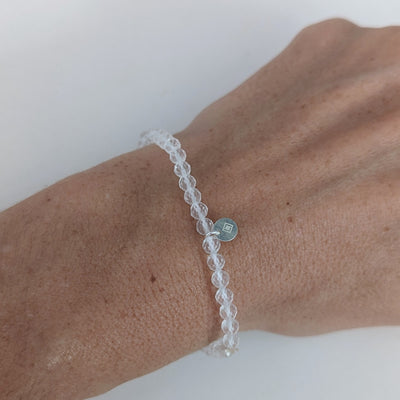 clear quartz 4mm faceted gemstone bracelet and sterling silver logo disc